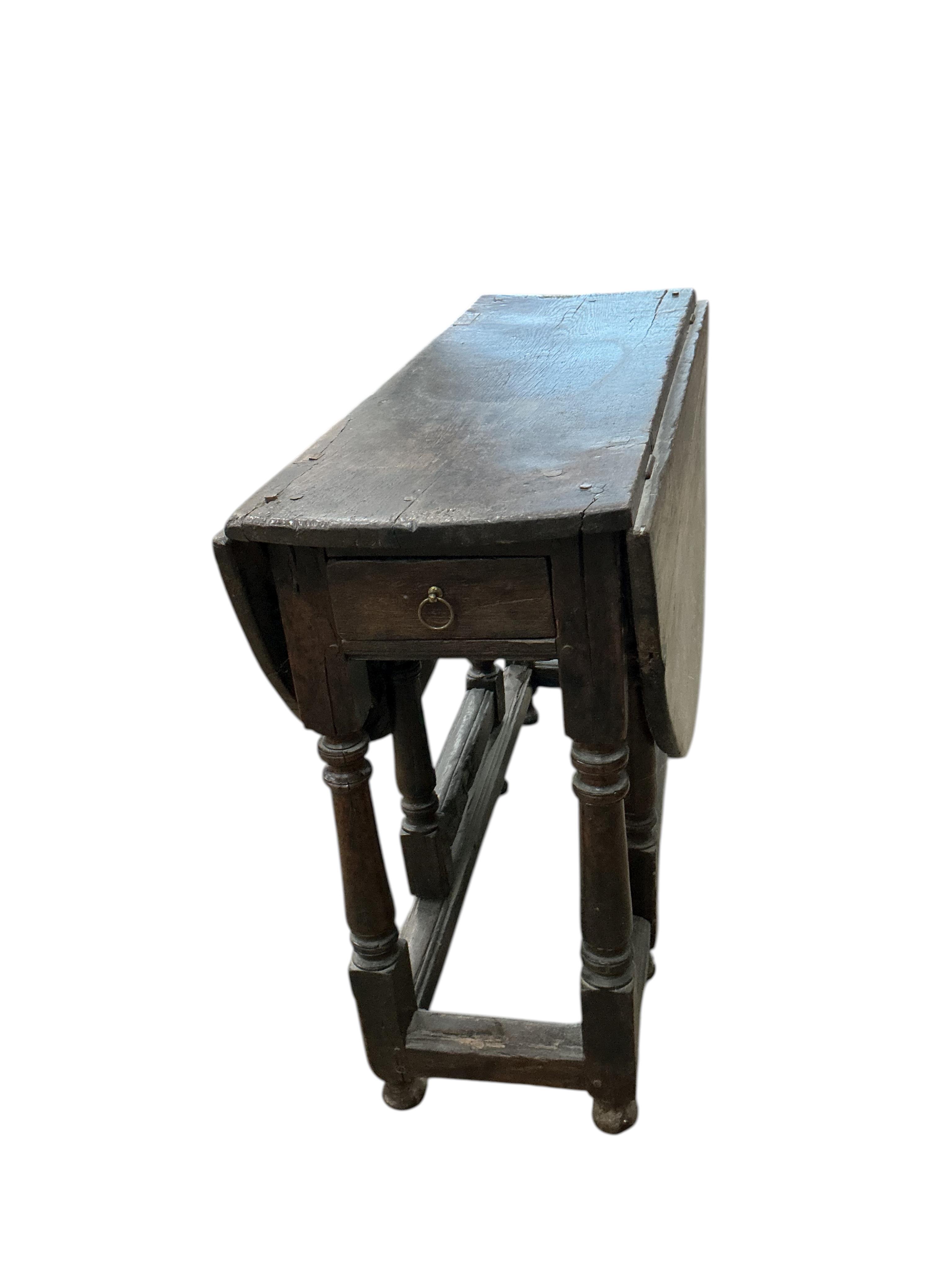 A late 17th / early 18th century oak gateleg table, width 100cm, depth 38cm, height 77cm
